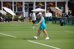 Players on court with Clubhouse in the background